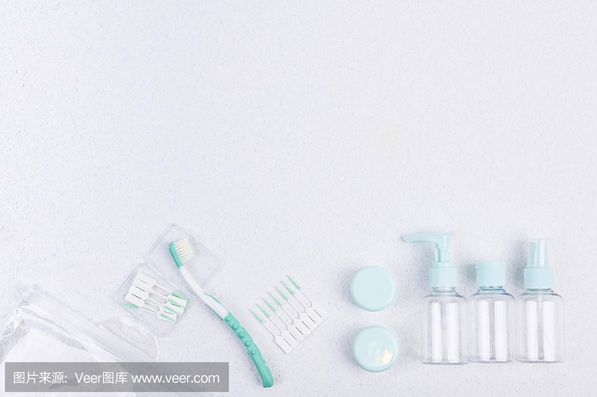 白色背景的牙刷、旅行用塑料容器和筷子。平的。